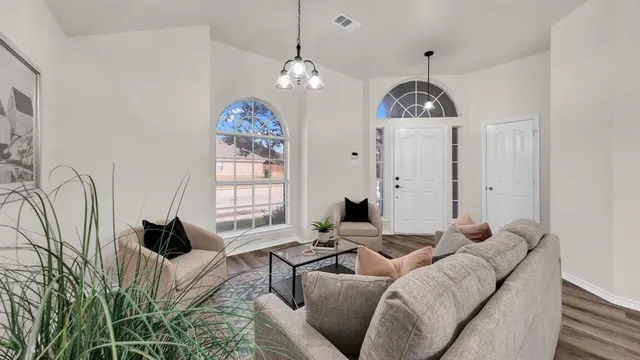 a living room with furniture chandelier and a window
