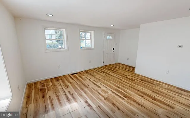 a view of a room with wooden floor and window