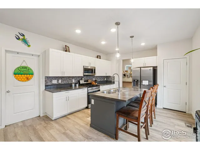 a kitchen with kitchen island wooden cabinets stainless steel appliances and refrigerator