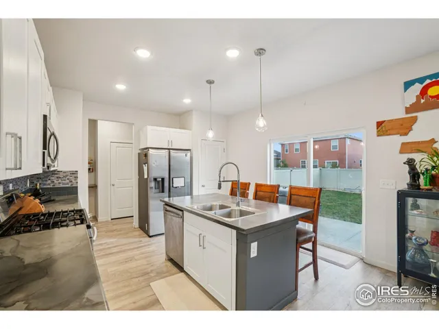 a kitchen with stainless steel appliances granite countertop a sink a stove and a refrigerator