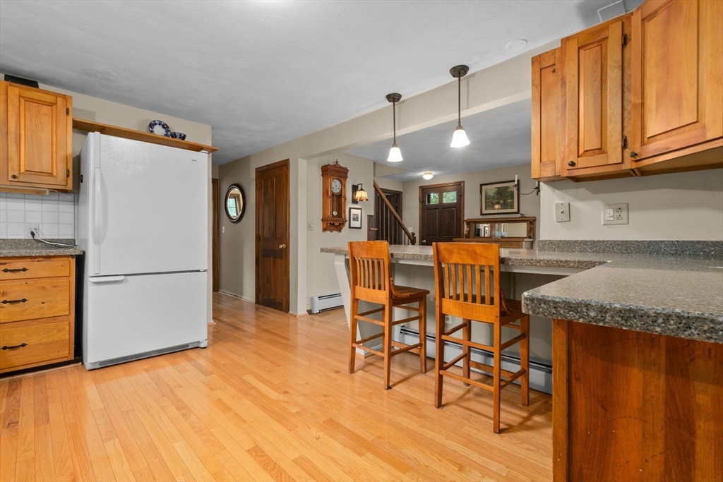 11 Heard Drive Ipswich, MA 01938 - Photo 6 of 41 a kitchen with stainless steel appliances granite countertop a refrigerator a microwave oven a sink dishwasher and white cabinets with wooden floor