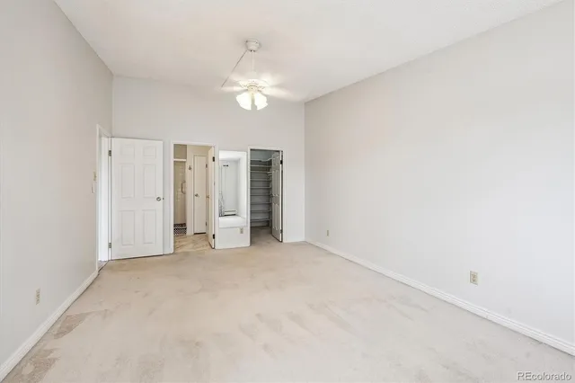 an empty room with chandelier fan