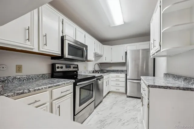 a kitchen with stainless steel appliances granite countertop a sink stove and microwave