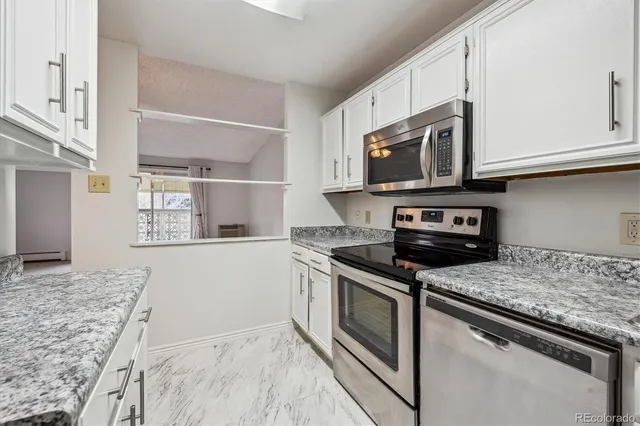 a kitchen with stainless steel appliances granite countertop a stove microwave and sink