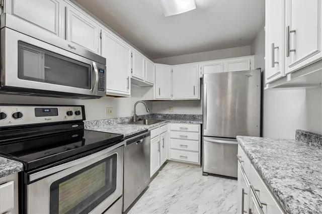 a kitchen with stainless steel appliances granite countertop a stove microwave and refrigerator