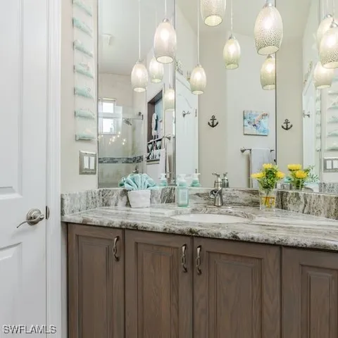 a bathroom with a granite countertop double vanity sink and a mirror