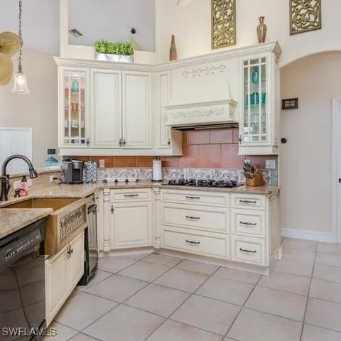 a kitchen with granite countertop white cabinets and white appliances