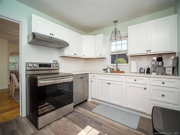 a kitchen with cabinets stainless steel appliances a sink and a stove