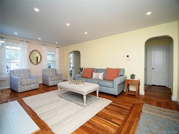 a living room with furniture and wooden floor
