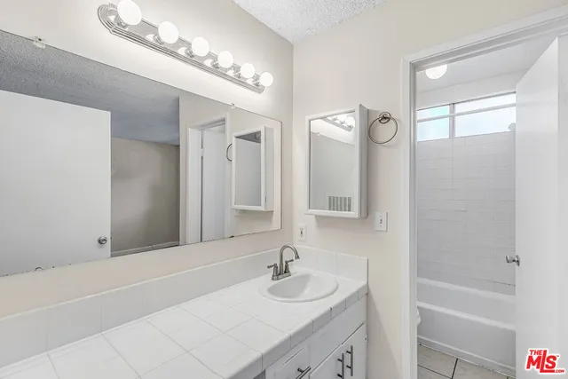 a bathroom with a sink a mirror and a bathtub