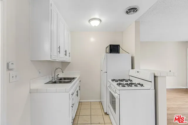 a kitchen with sink a stove and refrigerator