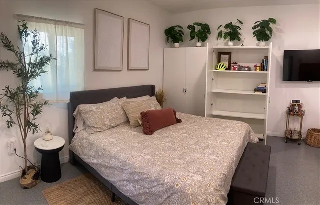 a bedroom with a bed and flat screen tv