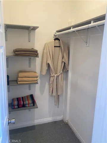 a view of walk in closet with clothes and shoes