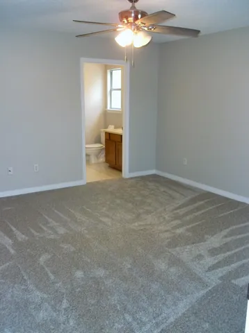 a view of an empty room with a chandelier fan