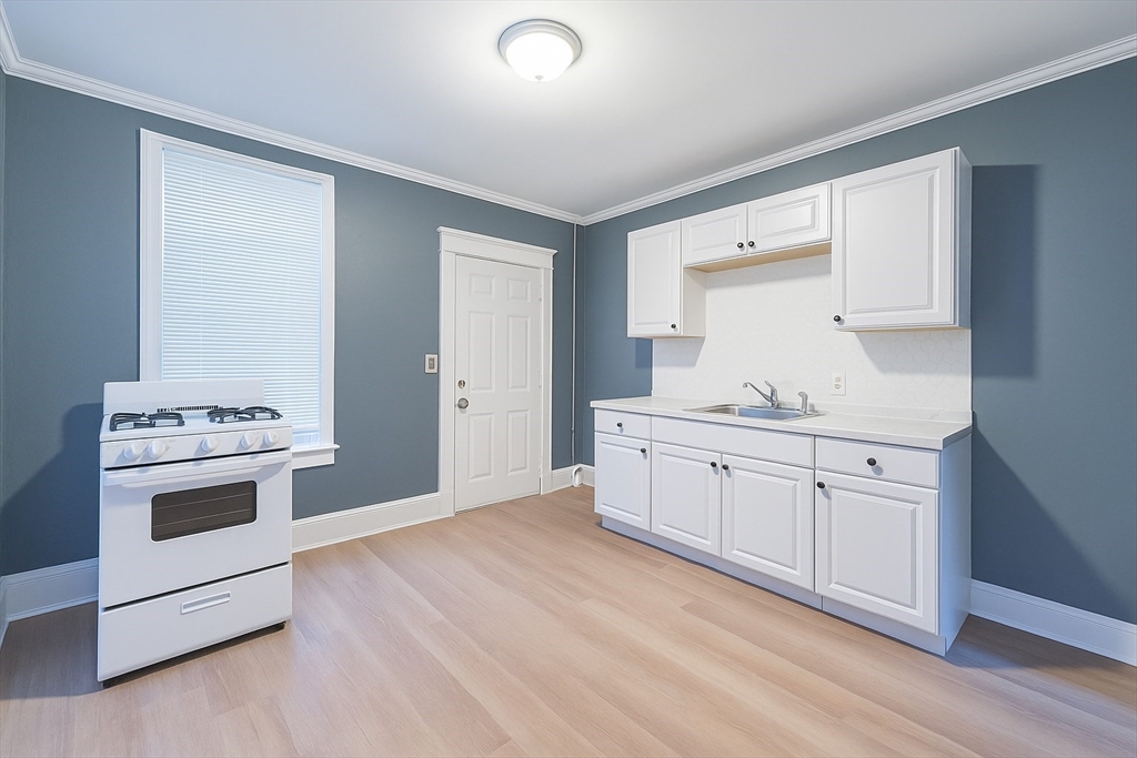 173 Elm Street, Unit 3LR Holyoke, MA 01040 - Photo 2 of 5 a kitchen with granite countertop white cabinets and white appliances