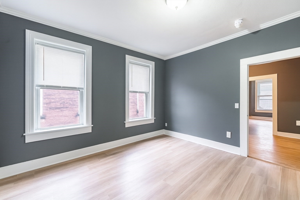173 Elm Street, Unit 3LR Holyoke, MA 01040 - Photo 4 of 5 a view of an empty room with wooden floor and a window