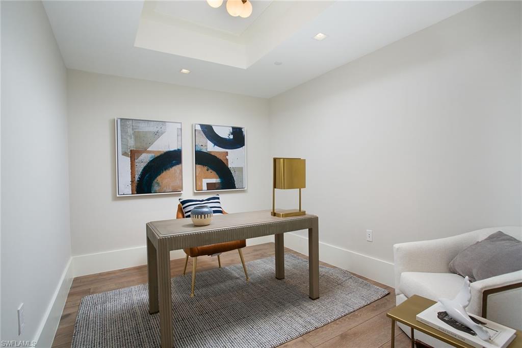 6897 Grenadier Boulevard, Unit 207 Naples, FL 34108 - Photo 12 of 27 a workspace with furniture and wooden floor