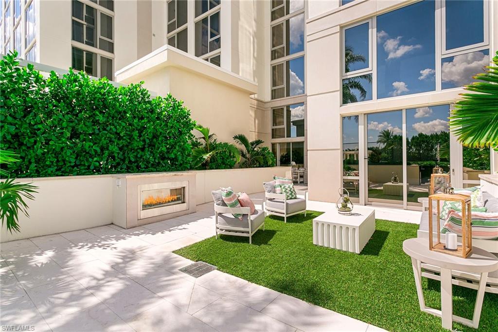 6897 Grenadier Boulevard, Unit 207 Naples, FL 34108 - Photo 19 of 27 a view of a patio with couches table and chairs and potted plants
