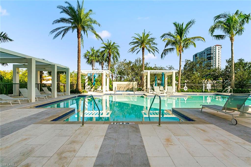 6897 Grenadier Boulevard, Unit 207 Naples, FL 34108 - Photo 21 of 27 a house with a garden and palm trees