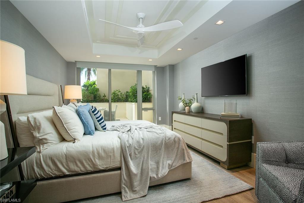 6897 Grenadier Boulevard, Unit 207 Naples, FL 34108 - Photo 22 of 27 a bedroom with a bed and a flat screen television