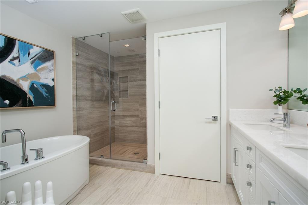 6897 Grenadier Boulevard, Unit 207 Naples, FL 34108 - Photo 23 of 27 a bathroom with a tub shower vanity granite and a sink