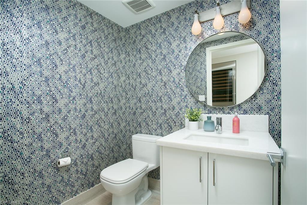 6897 Grenadier Boulevard, Unit 207 Naples, FL 34108 - Photo 24 of 27 a bathroom with a toilet sink and mirror