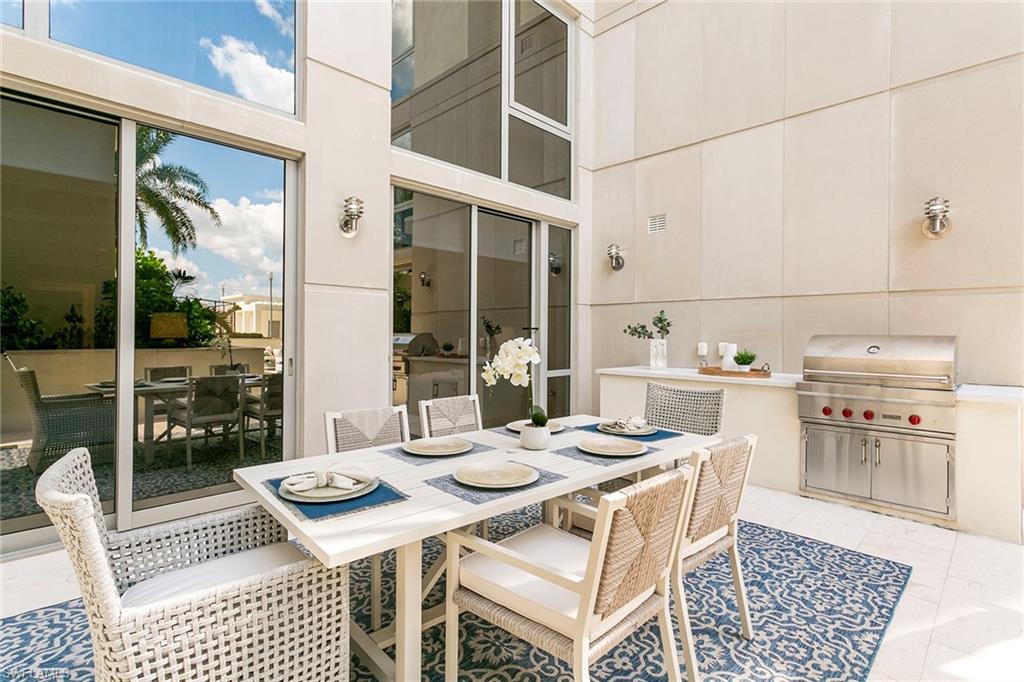 6897 Grenadier Boulevard, Unit 207 Naples, FL 34108 - Photo 6 of 27 a table and chairs in a patio