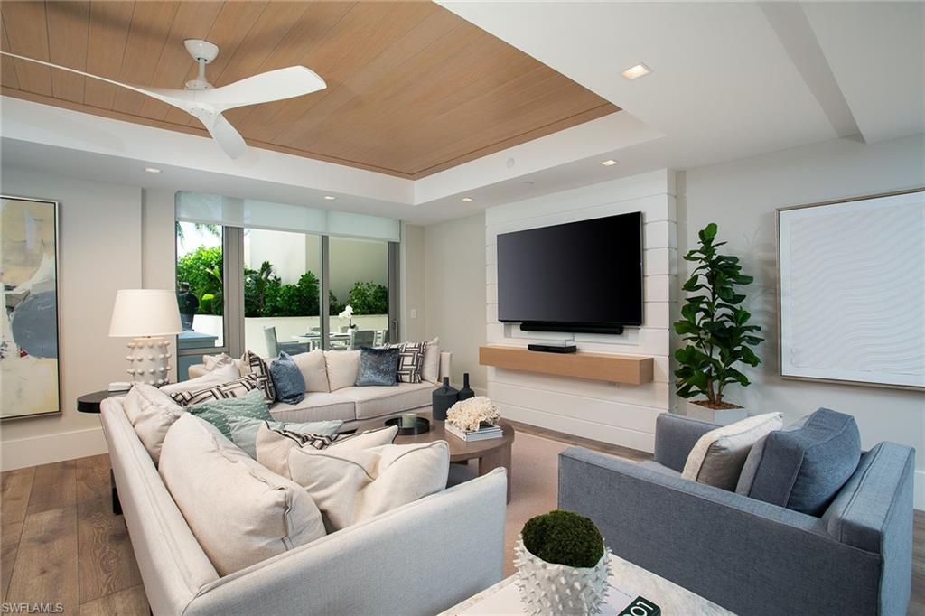 6897 Grenadier Boulevard, Unit 207 Naples, FL 34108 - Photo 8 of 27 a living room with furniture and a flat screen tv