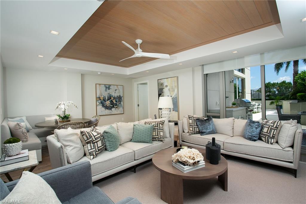 6897 Grenadier Boulevard, Unit 207 Naples, FL 34108 - Photo 9 of 27 a living room with furniture and a large window