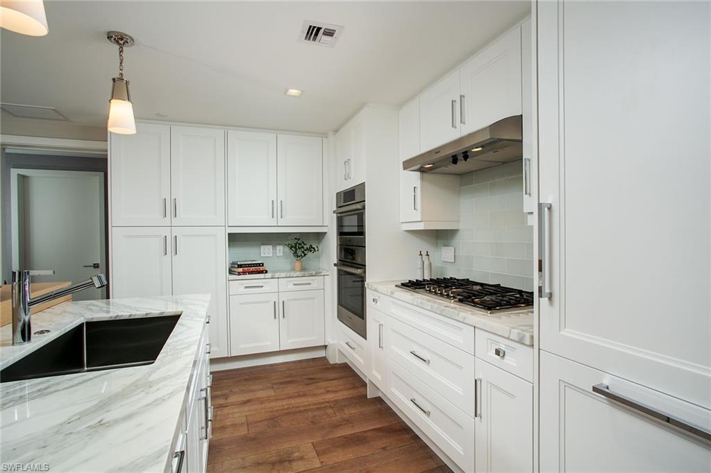 6897 Grenadier Boulevard, Unit 207 Naples, FL 34108 - Photo 10 of 27 a kitchen with white cabinets and appliances