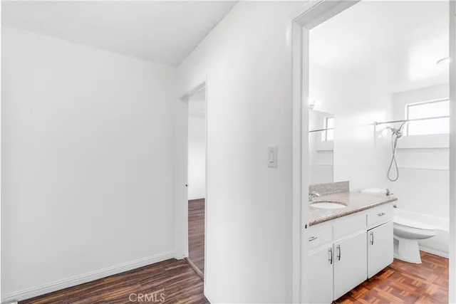 a bathroom with a granite countertop sink a toilet a shower and a mirror