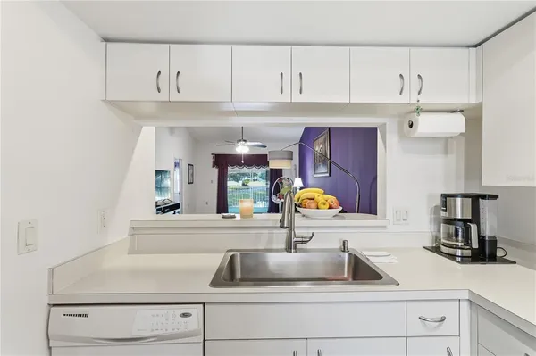 a kitchen with white cabinets a sink and dishwasher