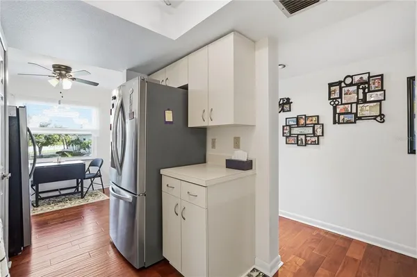a kitchen with stainless steel appliances a refrigerator sink and wooden floor