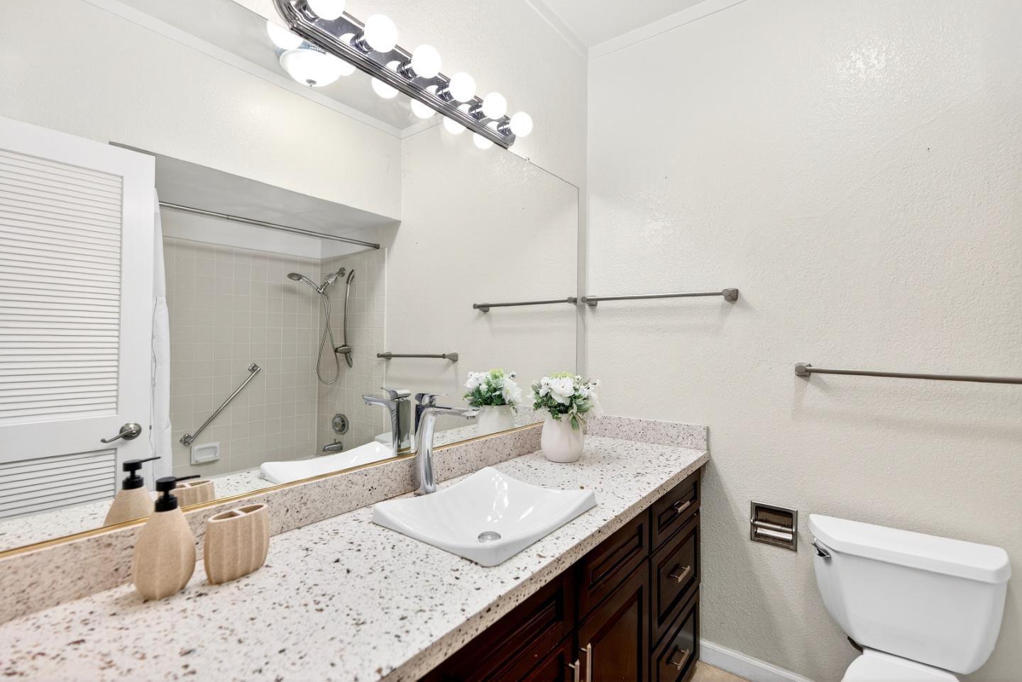 22330 Homestead Road, Unit 214 Cupertino, CA 95014 - Photo 16 of 35 a bathroom with a granite countertop sink a toilet a mirror and bathtub