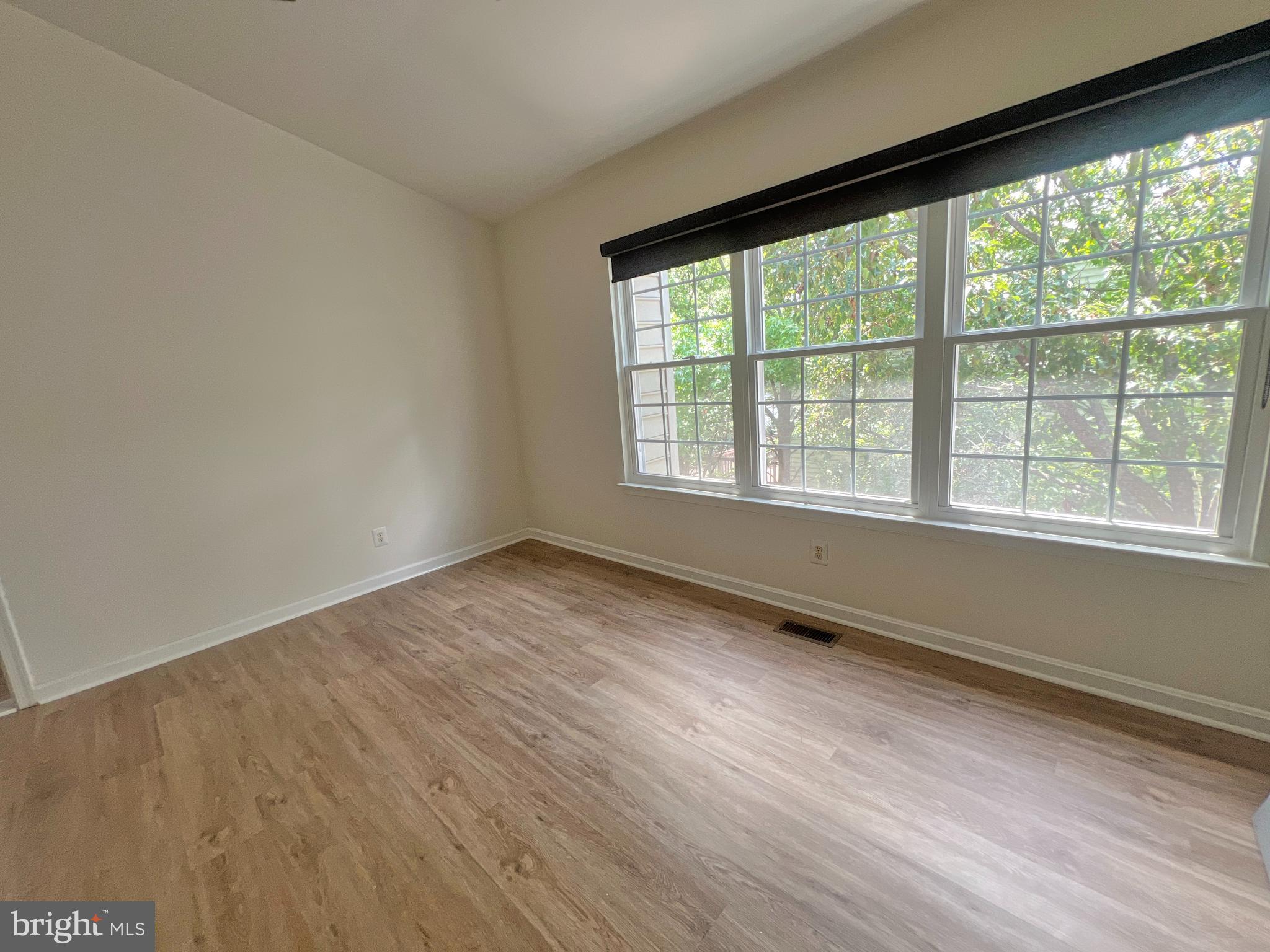 1191 Cypress Tree Place Herndon, VA 20170 - Photo 14 of 18 a view of an empty room with wooden floor and a window