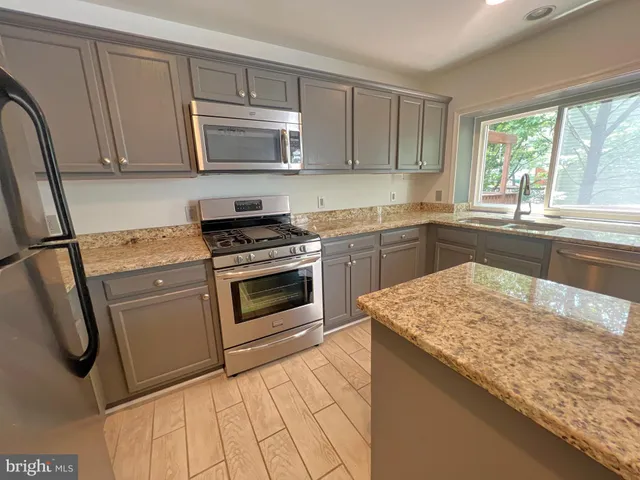 a kitchen with a sink refrigerator and microwave