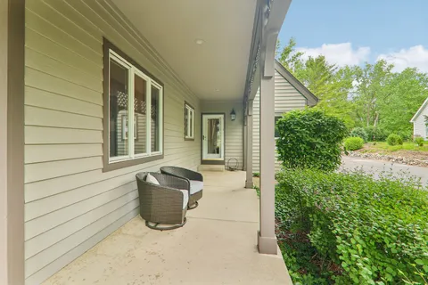 a view of a door and chair in back of the house