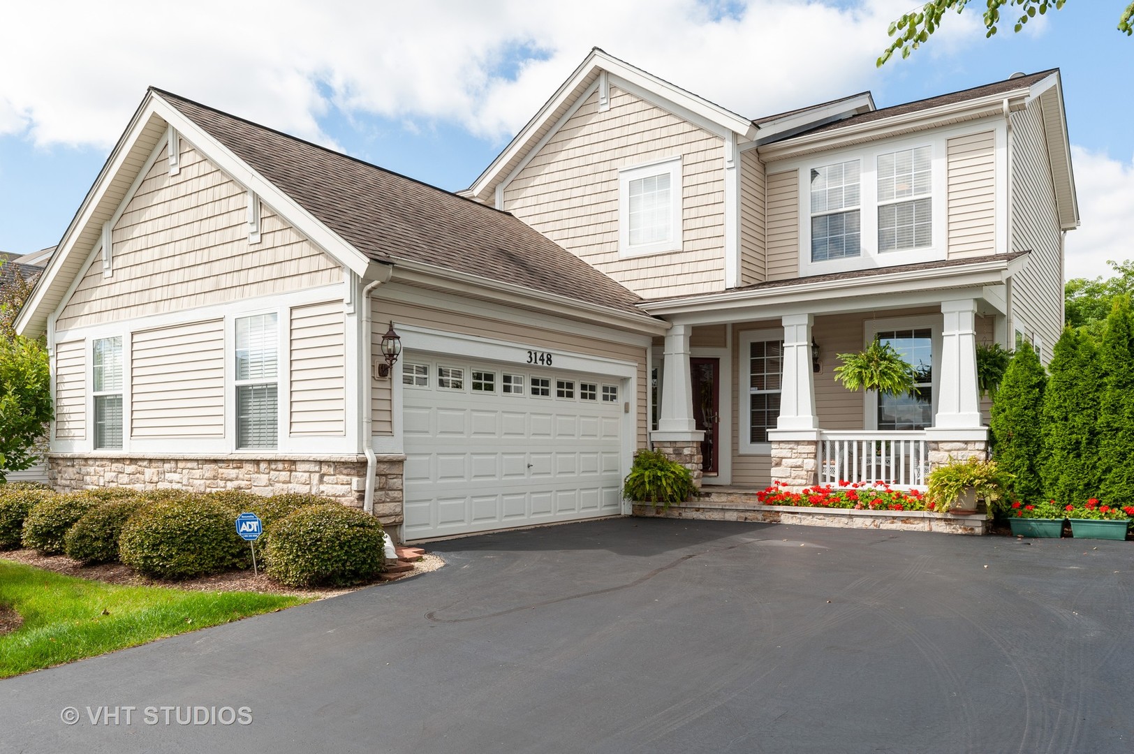 a front view of a house with a garden and plants