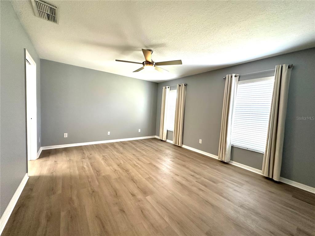 9706 Southwest 92nd Place Road Ocala, FL 34481 - Photo 11 of 82 an empty room with wooden floor and windows