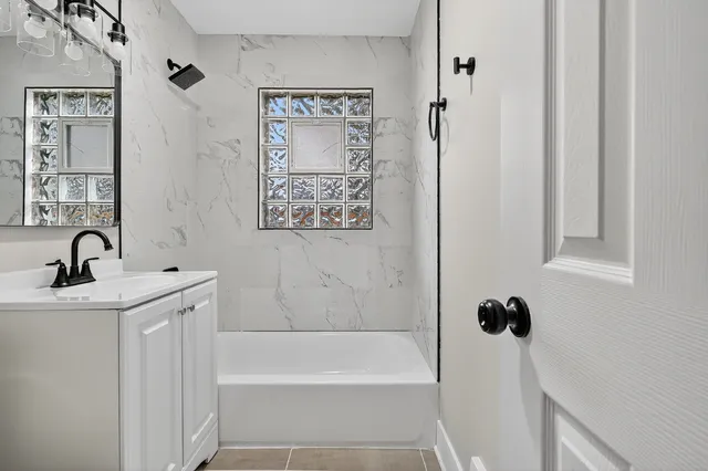 a bathroom with a bathtub sink and vanity