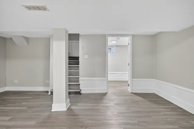 a view of an empty room with wooden floor and closet
