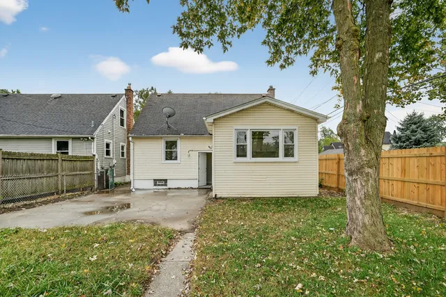 a view of a house with a large tree and a yard