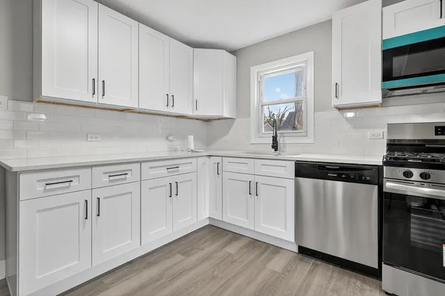 a kitchen with white cabinets and white appliances