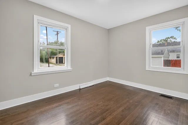 a view of empty room with window and wooden floor
