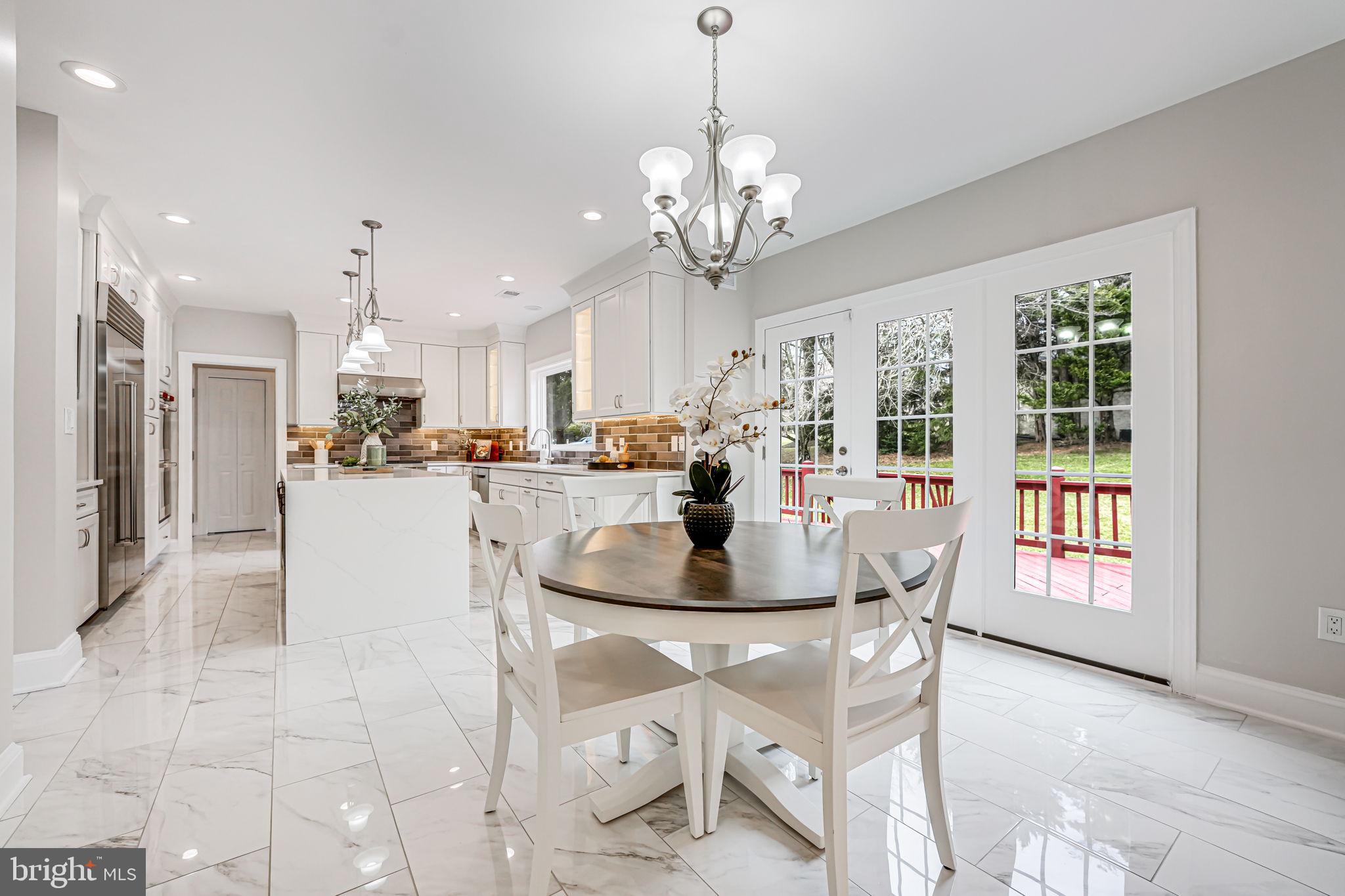 10800 Tradewind Drive Oakton, VA 22124 - Photo 22 of 77 a view of a dining room with furniture a chandelier and kitchen view
