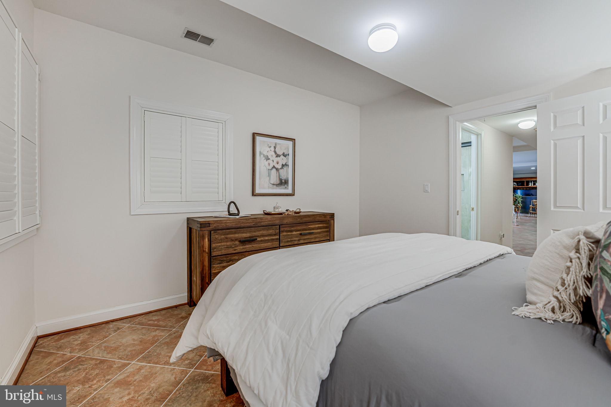 10800 Tradewind Drive Oakton, VA 22124 - Photo 60 of 77 a bedroom with a bed and a cabinets