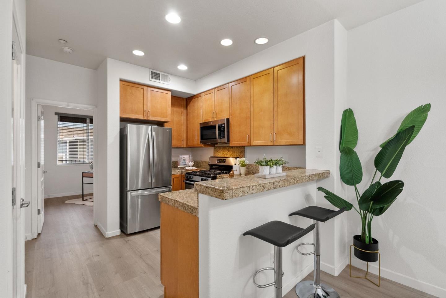 658 Kingsford Way Hayward, CA 94541 - Photo 11 of 38 a kitchen with stainless steel appliances granite countertop a refrigerator a sink a stove a dining table and chairs