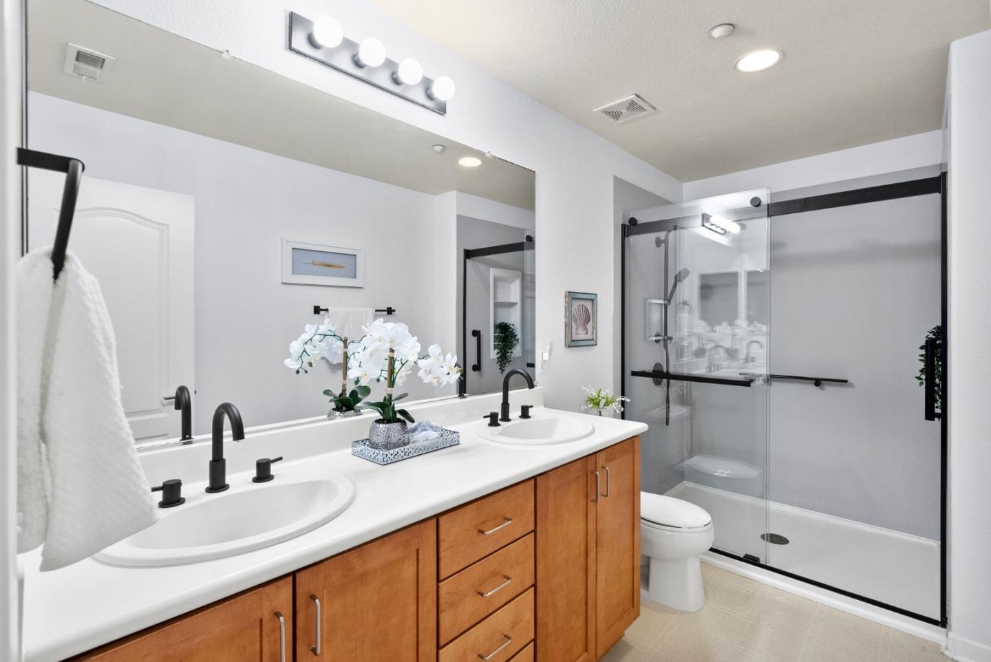 658 Kingsford Way Hayward, CA 94541 - Photo 19 of 38 a bathroom with a double vanity sink toilet mirror and shower