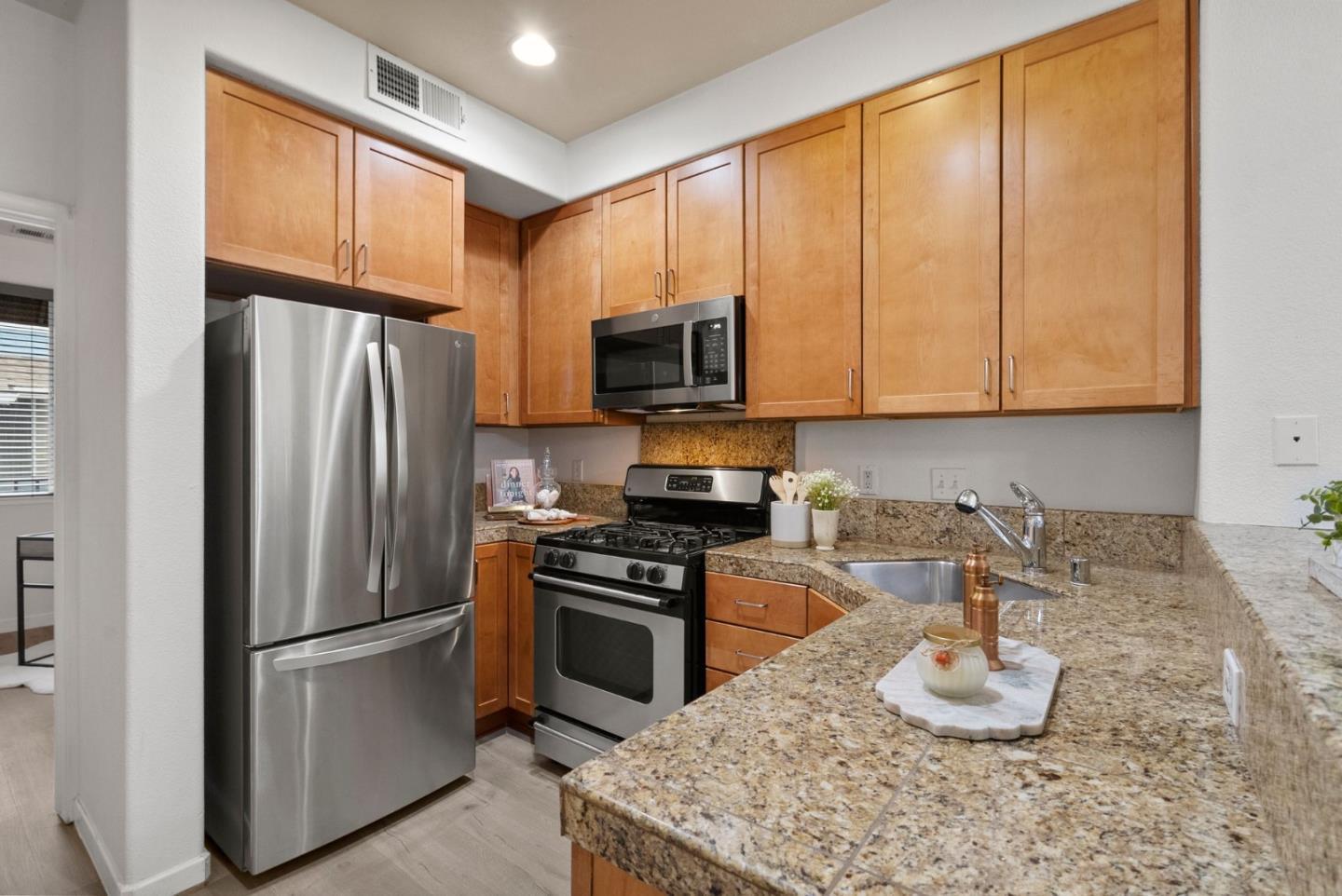 658 Kingsford Way Hayward, CA 94541 - Photo 10 of 38 a kitchen with granite countertop stainless steel appliances a stove refrigerator and microwave
