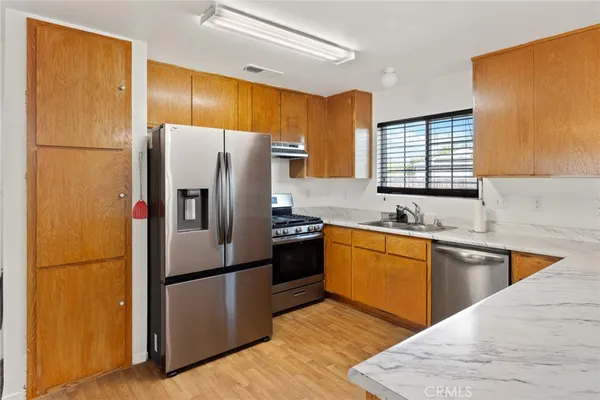 a kitchen with stainless steel appliances granite countertop a refrigerator stove microwave and sink